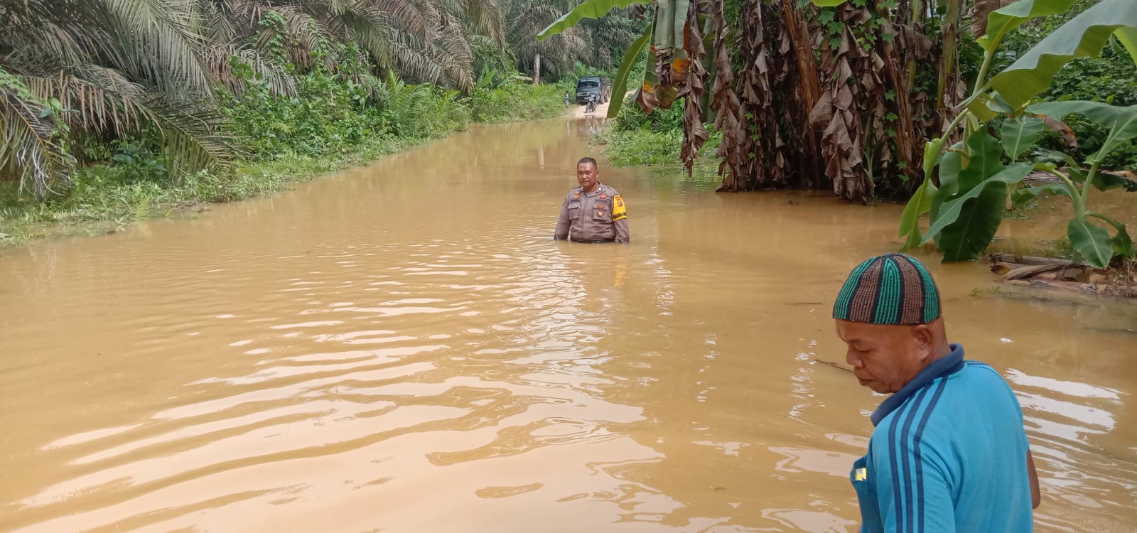 Banjir, Polisi di Inhu Berendam Bantu Warga Melintasi Jalan